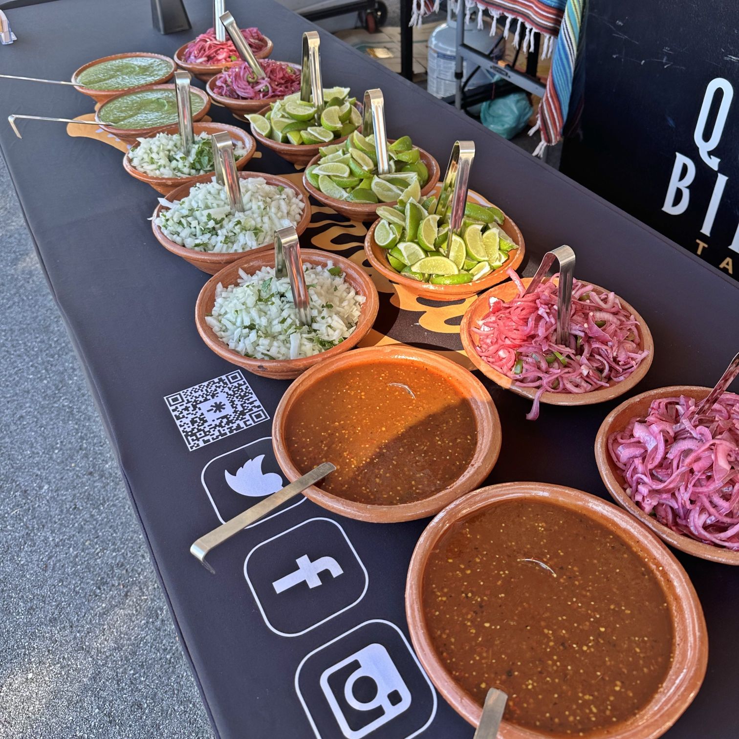 805 Quesa Birria Tacos catering salsa and toppings bar set for a large event.